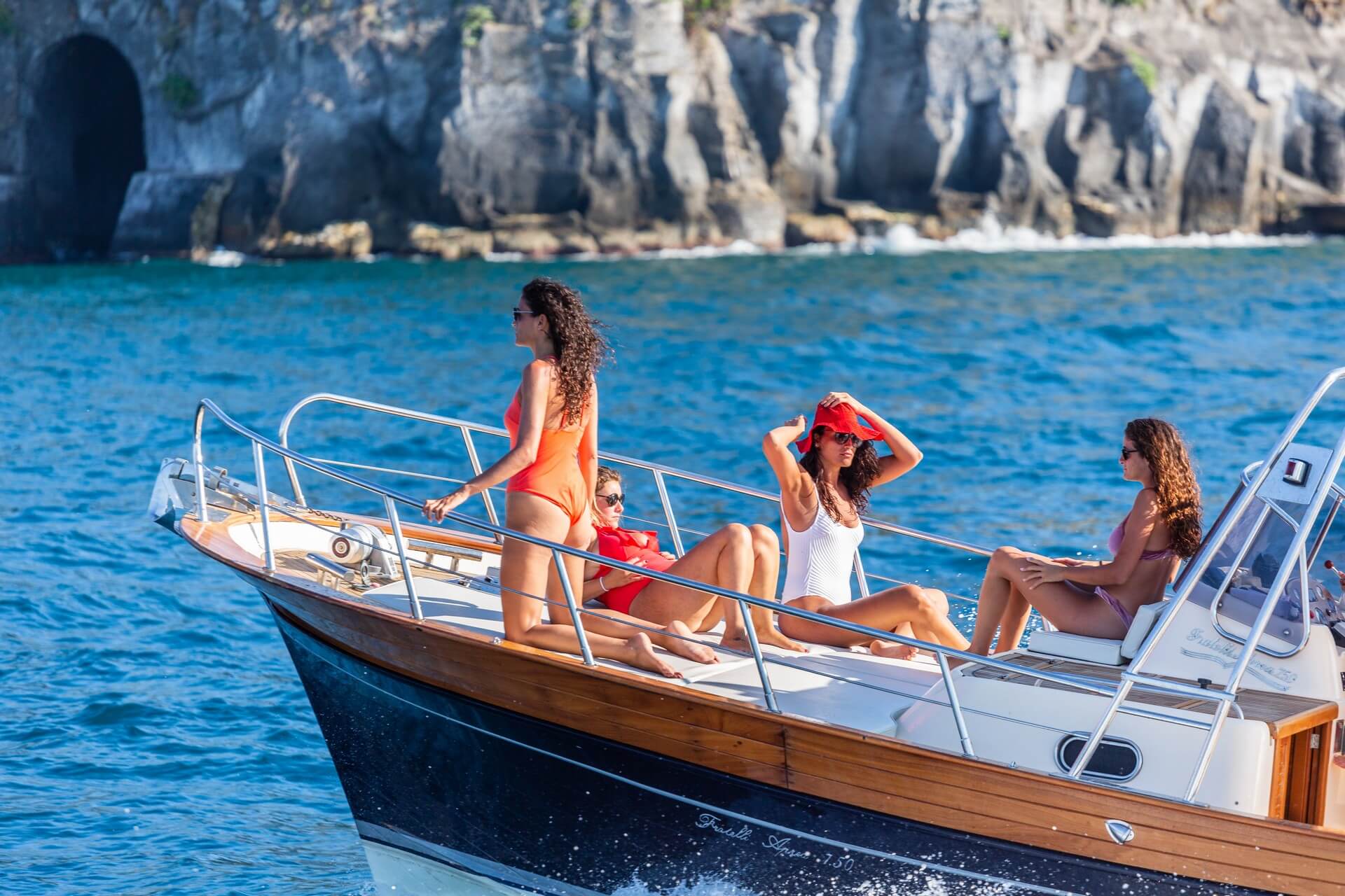 Private yacht passing through Capri's Faraglioni arch